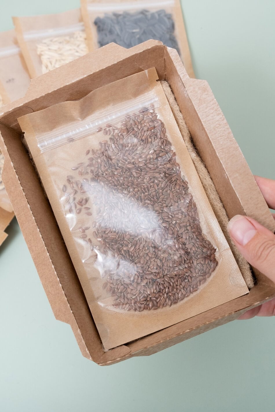Kartonbehälter mit Leinenteppich und Samen. Öko-Box für den Anbau von Microgreens